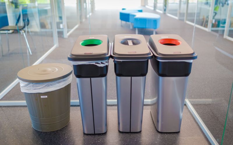 Bildet viser tre avfallsdunker plassert i kontorlandskap