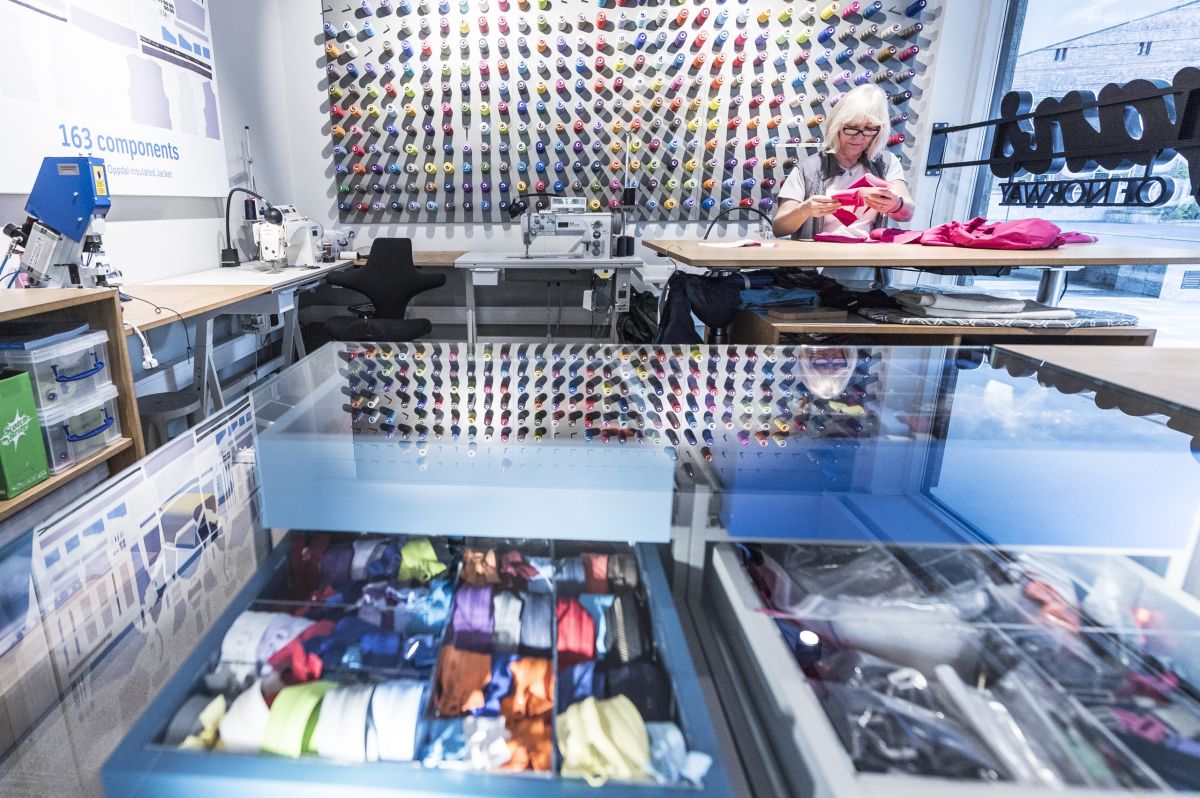 Bildet viser Bergans sin systue i butikk med en dame som reparerer klær