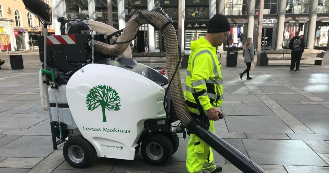 Arbeider som bruker kostemaskin