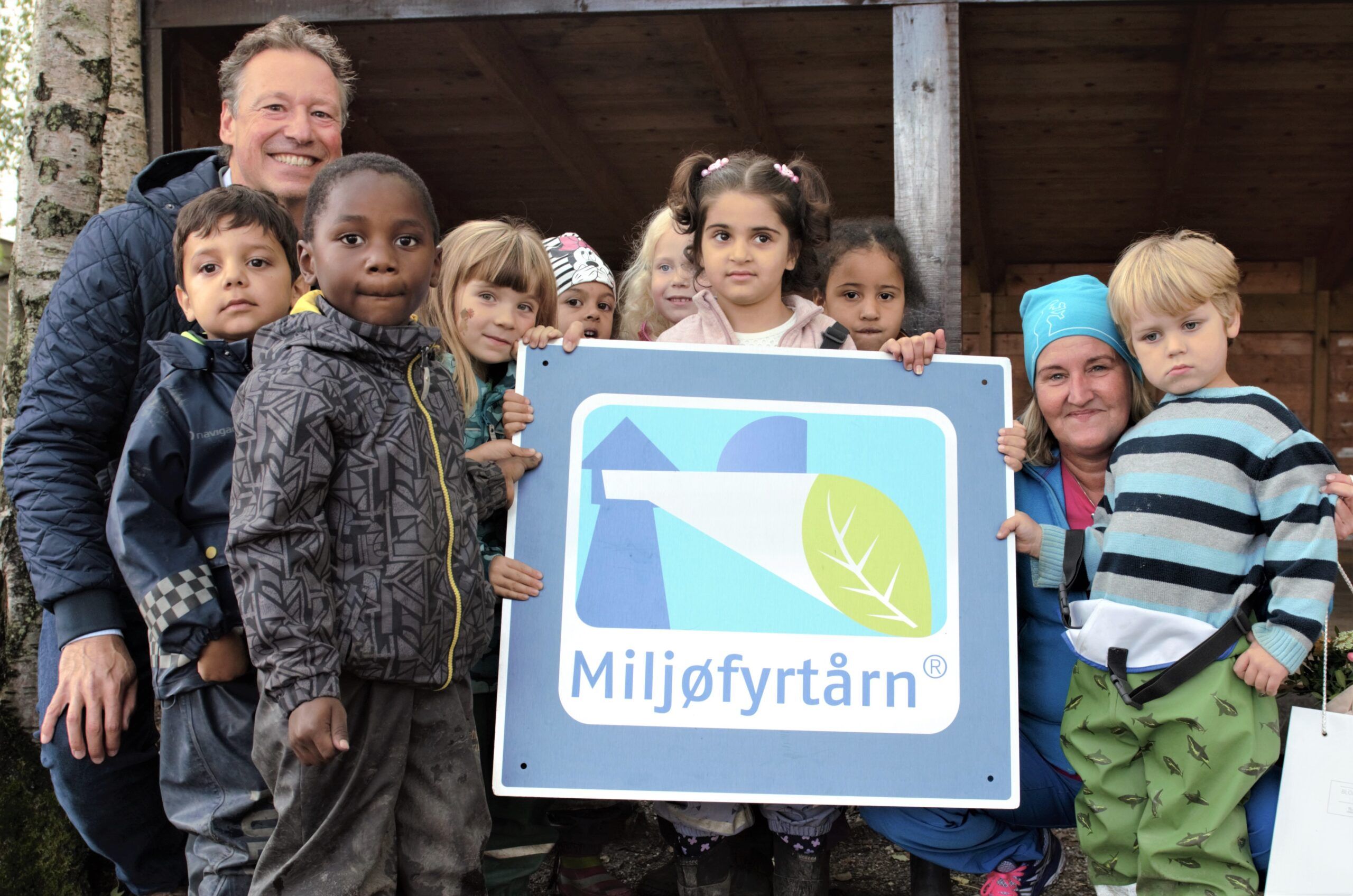 Barn i barnehagen står oppstilt og holder frem Miljøfyrtårn-diplom Barn i barnehagen står oppstilt og holder frem Miljøfyrtårn-diplom