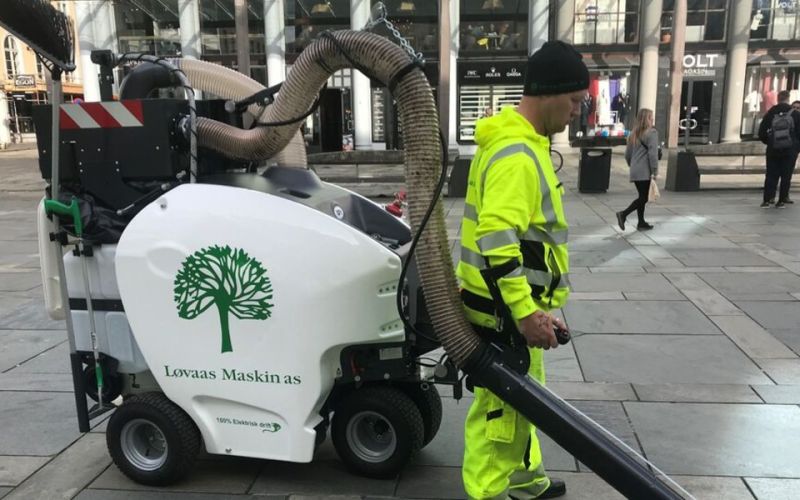 Arbeider som bruker kostemaskin