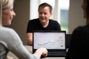 Dame som peker på laptop med graf