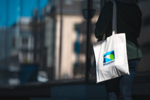 dame bærer handlenett med bybakgrunn