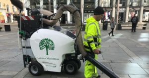 Arbeider som bruker kostemaskin