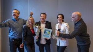 Mennesker som jubler med blomst og diplom