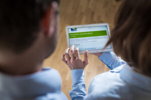 Dame som holder en ipad med klima- og miljørapport