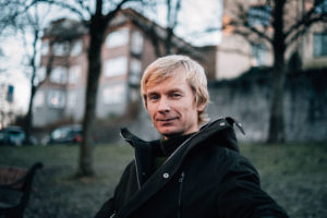 Miljøsjef i Vinmonopolet sitter på en benk ute