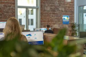 Kontorlandskap med en mann og dame foran PC