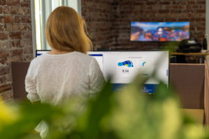 Bilde av dame ei kontorlandskap foran PC-skjerm