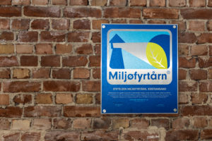 Bilde av et Miljøfyrtårn-diplom hengende på murvegg