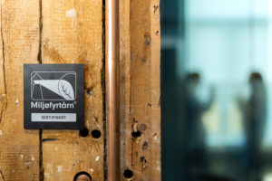 Bilde sort Miljøfyrtårn-aluminiumsplakett hengende på trevegg