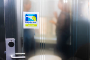 Bilde av farget Miljøfyrtårnklistremerke på møteromdsdør