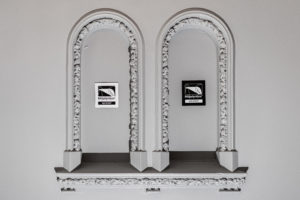 Bilde av to sort-hvite Miljøfyrtårnplaketter hengende på fasadevegg