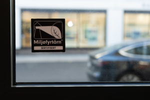 Bilde av et miljøfyrtårnklistremerke i svart-hvitt på vindu