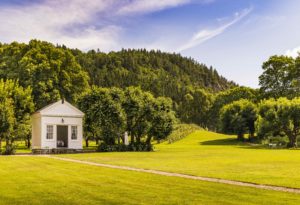 Oversiktsbilde over Boen gård med velstelt plen i forgrunn