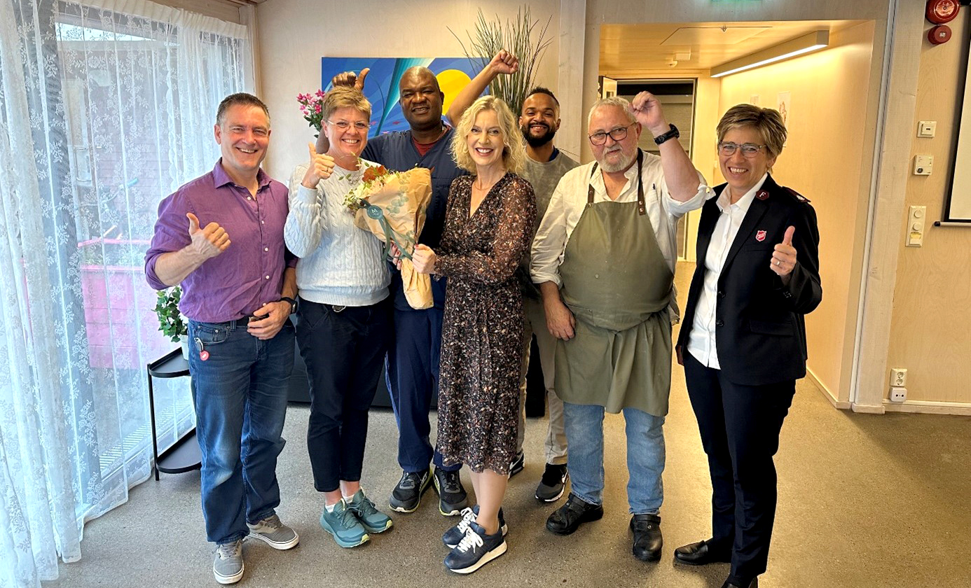 Bildet viser en gruppe blide mennesker som står oppstil tog smiler mot kamera.