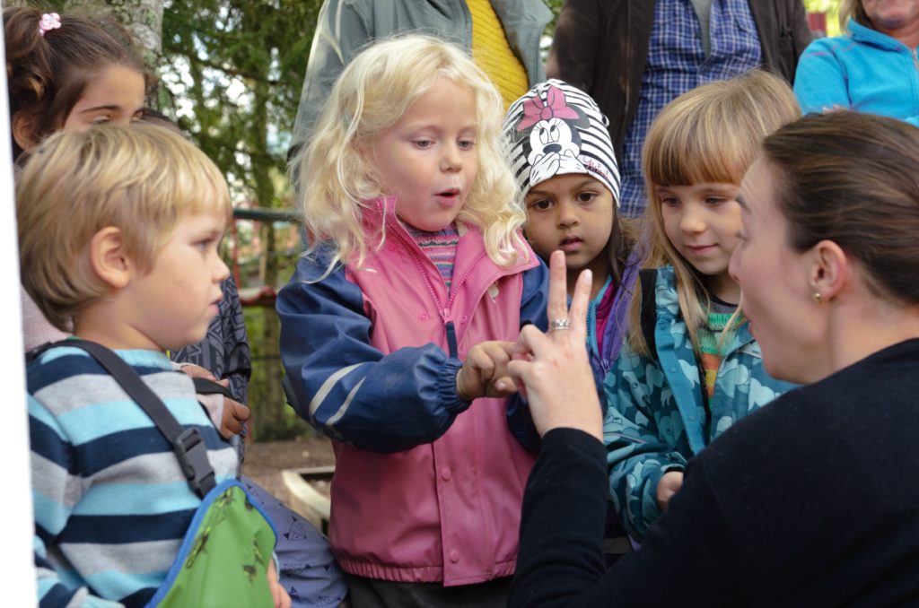 Barn prater med voksne i barnehagen