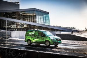 Grønn elbil kjører på veien