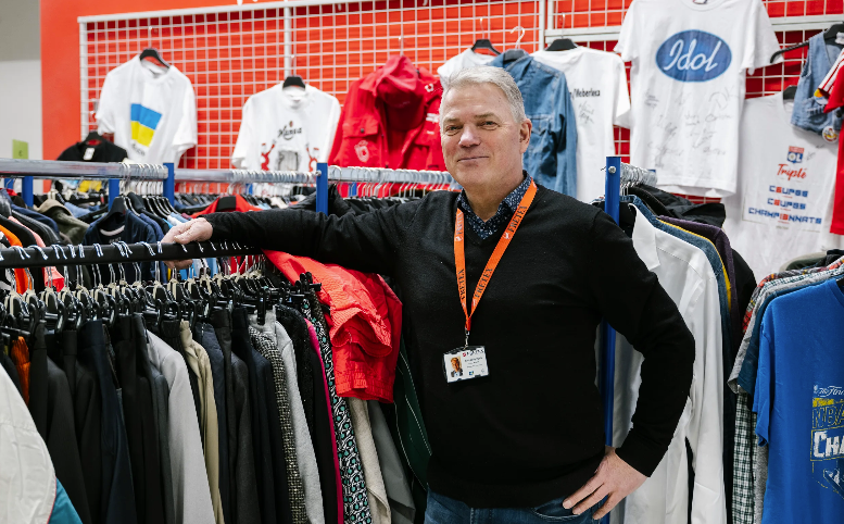 Arnt-Willy Hjelle i Fretex står foran klær i sorteringshallen.